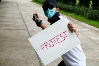 Rear view of woman holding text on street