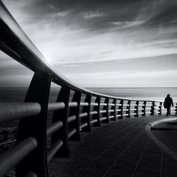 Pier on sea against cloudy sky