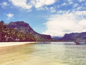 Scenic view of sea and mountains against sky