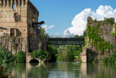 Arch bridge over river against sky