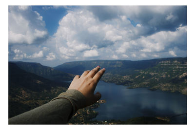 Low angle view of human hand against sky