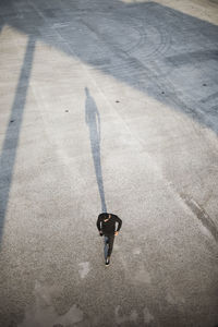 High angle view of man using smart phone while walking on footpath