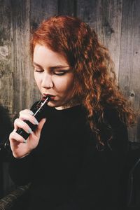 High angle view of young woman holding mobile phone