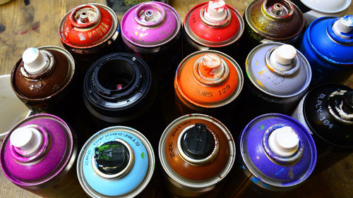 Close-up of colorful aerosol cans on table
