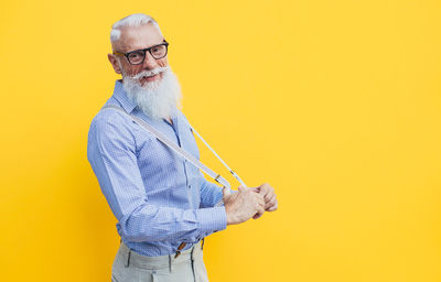 Senior man against yellow background