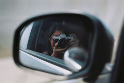 Portrait of man photographing car