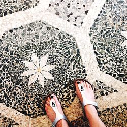 Low section of person standing on tiled floor