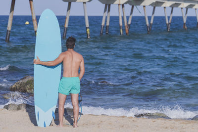 Rear view of shirtless man at beach