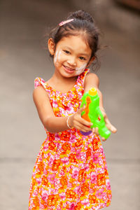 Cute girl holding baby while standing outdoors