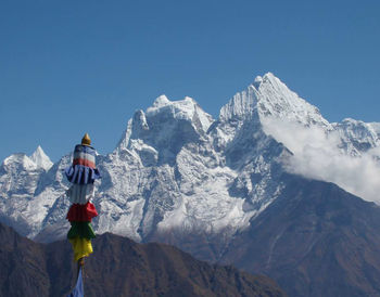 Low angle view of snowcapped mountains against clear sky