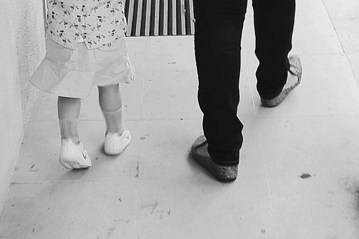 LOW SECTION OF WOMAN STANDING ON FLOOR