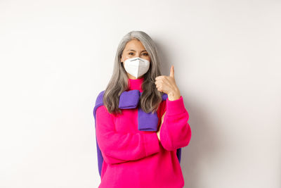 Portrait of woman standing against white background