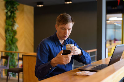 Man looking at camera while sitting on table