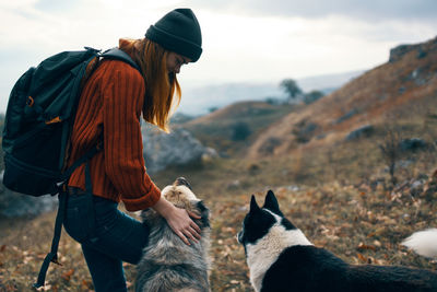 Rear view of person with dog in snow