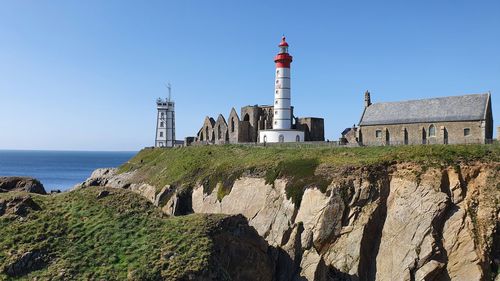 View of lighthouse against buildings and sea