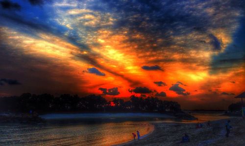 Scenic view of sea against cloudy sky at sunset