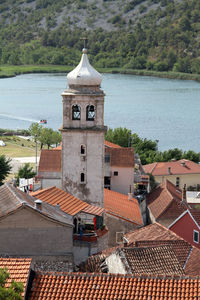 High angle view of townscape by sea against sky