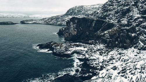 Rock formation in sea against sky