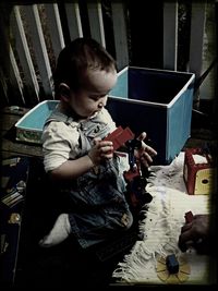 Portrait of cute boy sitting on wall