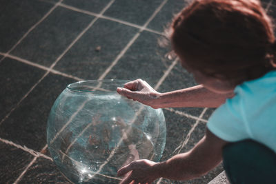 Close-up of woman holding glass container at fountain