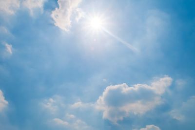 Low angle view of sunlight streaming through clouds