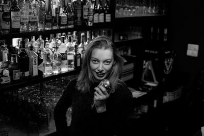 Portrait of smiling young woman singing in bar