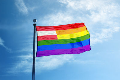 Low angle view of flags against blue sky