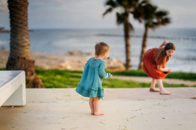 Girl with sibling playing on promenade