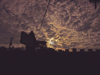 Silhouette of building against cloudy sky