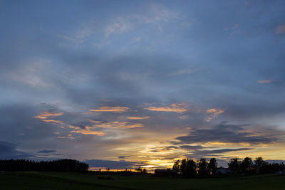 Silhouette field against sky during sunset