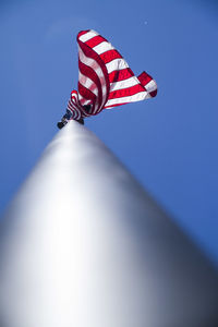 Low angle view of flag against clear blue sky