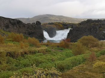 Scenic view of waterfall against sky