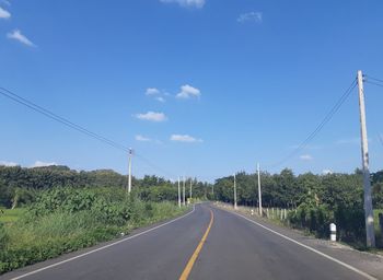 Road amidst plants against sky