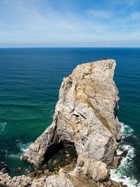 Rock formation in sea against sky