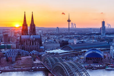 Aerial view of buildings in city at sunset