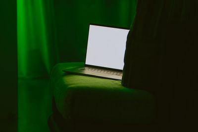 Close-up of laptop on table in darkroom