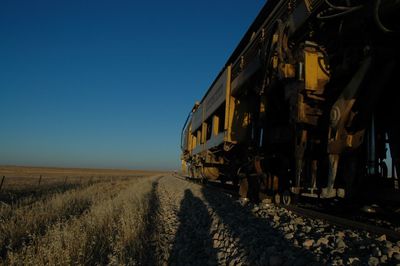 Locomotive of freight train on field against clear sky