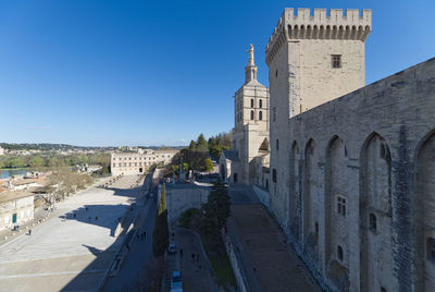 Buildings in city against clear blue sky