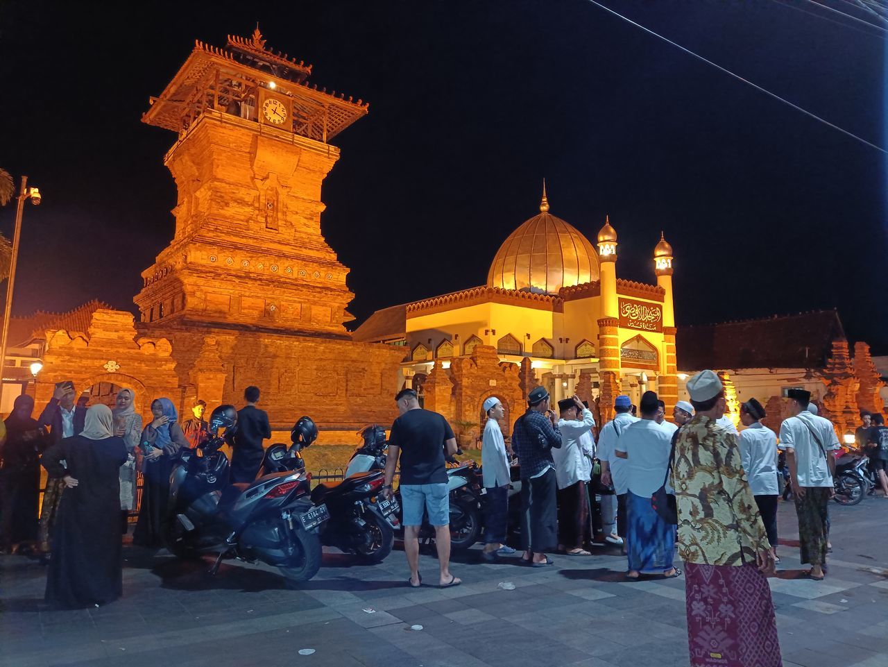 architecture, night, group of people, religion, travel destinations, crowd, large group of people, built structure, belief, building exterior, history, travel, city, the past, tourism, spirituality, temple - building, place of worship, illuminated, building, nature, tradition, men, ancient, temple, adult, street, sky, outdoors, tourist, evening