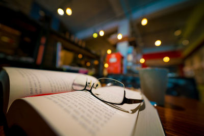 Close-up of eyeglasses on book at table in restaurant