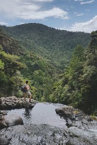 Male hiker standing on mountains against sky