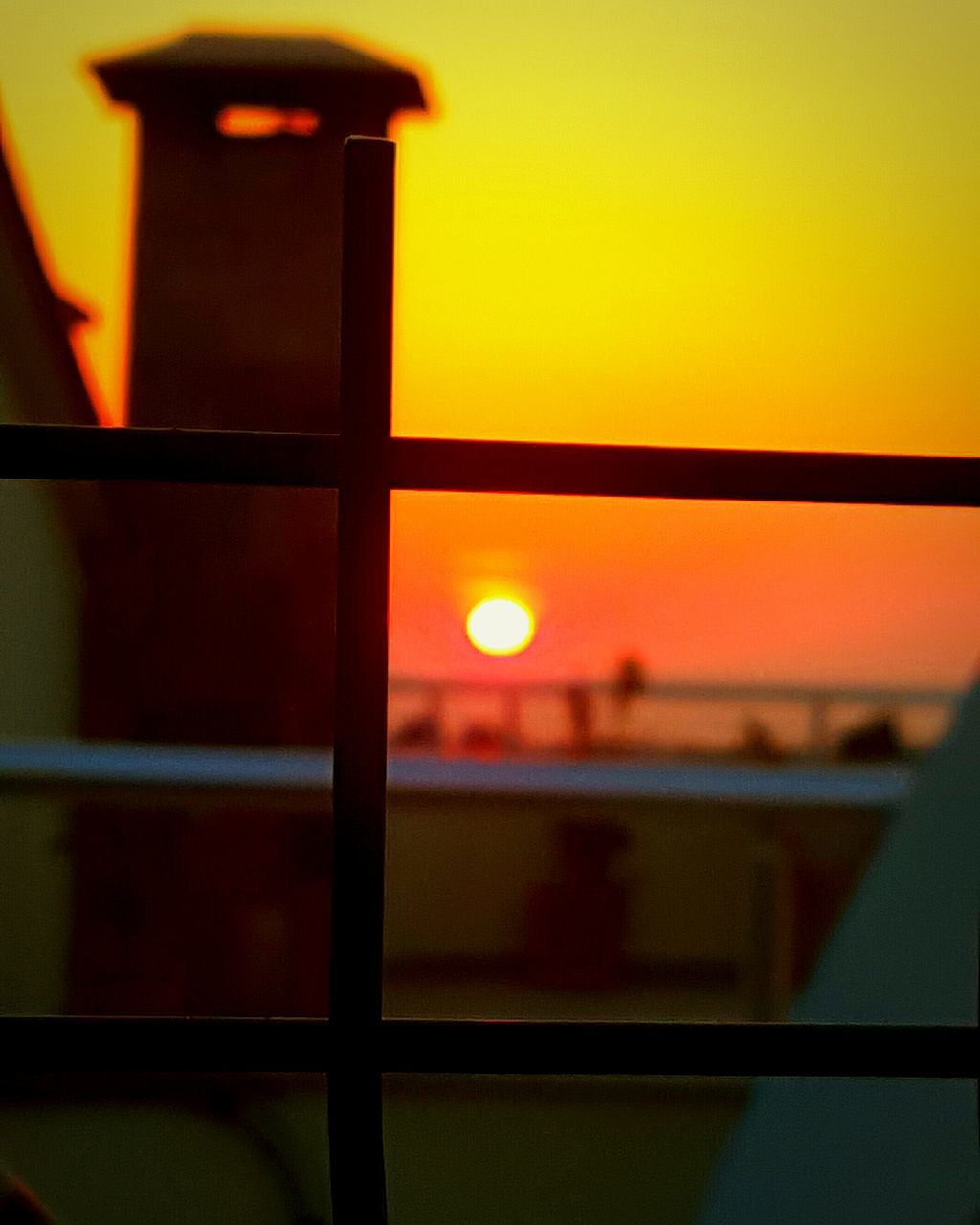 sunset, orange color, sun, indoors, window, built structure, yellow, sky, architecture, sea, no people, horizon over water, reflection, focus on foreground, scenics, building exterior, nature, sunlight, close-up, glass - material