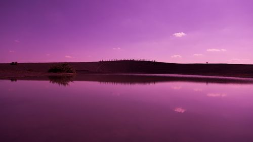 Scenic view of lake against sky at sunset