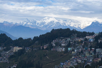 Aerial view of townscape and mountains against sky