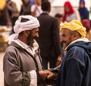 Smiling friends doing handshake