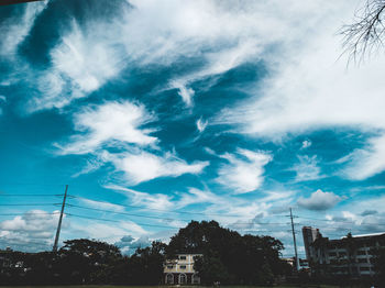 Low angle view of buildings against cloudy sky