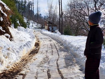 Rear view of person on snow covered road