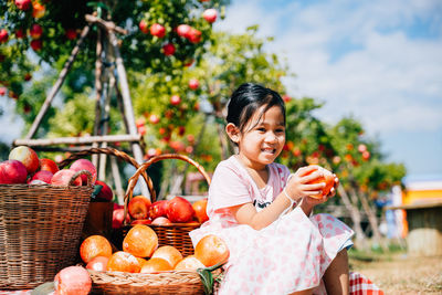 Portrait of young woman holding fruits