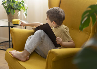 Young woman using laptop while sitting on sofa at home