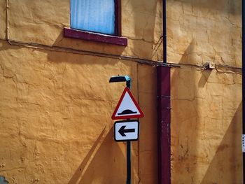 Close-up of road sign against built structure